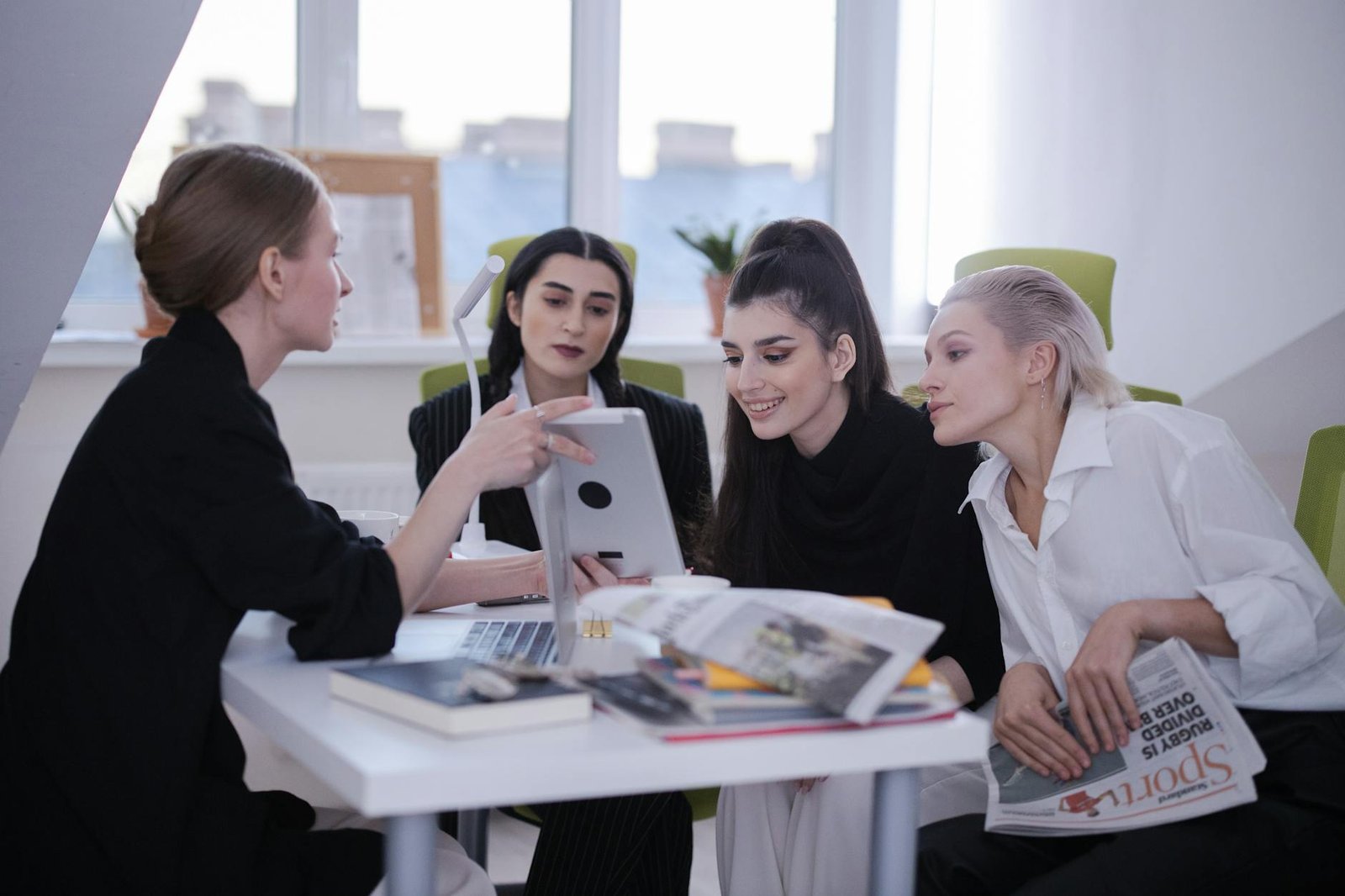 a group of women sitting while looking at the tablet